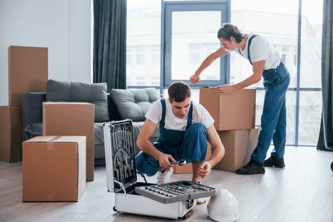 two-young-movers-in-blue-uniform-working-indoors-in-the-room.jpg
